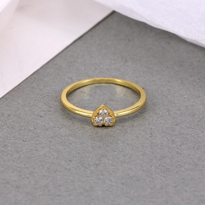 Close-up of a slim gold heart ring featuring three tiny sparkling round-cut crystals