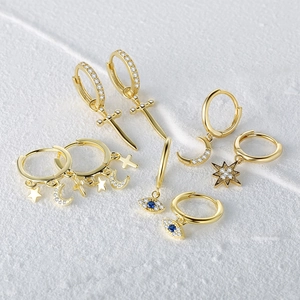 Macro detail of S925 silver star and moon earrings with gold plating and zircon
