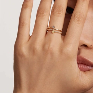 Close-up of double-layer gold silver ring with pavé diamonds and a round gemstone