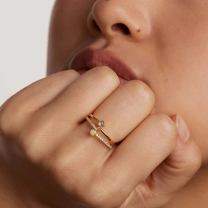 Close-up of elegant gold stacking rings with a single stone and pavé setting on finger