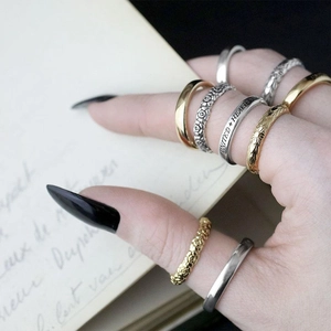 Detailed macro view of vintage silver and gold stacked rings with floral engravings