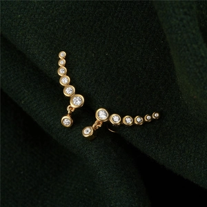 Makro-Detail von S925 Sterling Silber Gold Ohrringen mit funkelnden Zirkonsteinen
