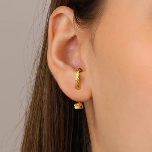Macro view of gold snake-shaped ear cuff featuring detailed scales and wrap-around design