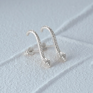 Detailed close-up of S925 sterling silver snake earrings showing scales and metal hallmark