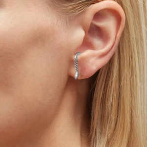 Macro shot of silver snake ear cuff with detailed scale carving on female ear