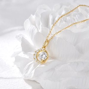 Gros plan du collier croissant de lune doré avec cristaux sur des pétales de fleurs