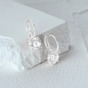 Detailopname van het S925 zilvermerk en de fonkelende ronde diamanten oorbel