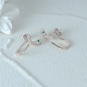 Detailed macro view of S925 sterling silver snake stud earrings with green zircon eyes