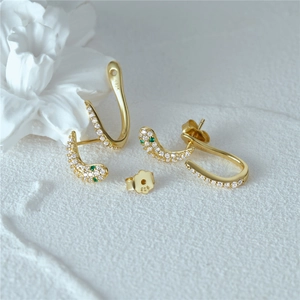Detail of S925 sterling silver snake earrings with white zircons and green gemstones