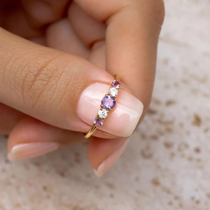Detail of gold-plated S925 silver ring featuring five purple and white round zircons
