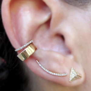 Close-up of golden ear cuff set with pavé cubic zirconia studs and climbers on ear