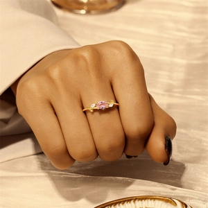 Detailed view of an elegant gold branch ring with oval pink gemstone and marquise side stones