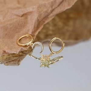 Detailed view of S925 silver gold-plated moon and star asymmetric earrings on reflective base