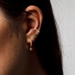 S925 silver asymmetric star and moon earrings set with zircons in golden finish on ear