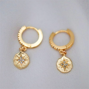 Detailed macro of gold plated star moon pendant earrings with zircon stones