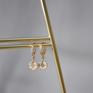 Detail of S925 silver gold-plated starburst hoop earrings with sparkling zircon stones