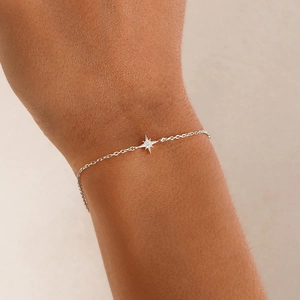Detail of s925 sterling silver star bracelet with shimmering diamond on a female wrist