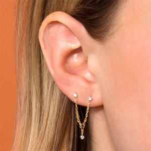 Detail van s925 zilveren gouden ketting oorbellen met hart zirkoon op model