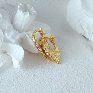 Macro shot of S925 silver gold-plated fan-shaped earrings with pink and clear zircons