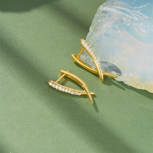 Detail of 18K gold-plated V-shaped huggie earrings with sparkling white zircon stones