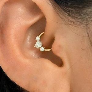 Macro view of gold s925 silver daith piercing ring with opal and teardrop stones