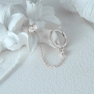 Detailopname van S925 zilveren ketting oorbellen met hart zirkoon op witte bloemen steun