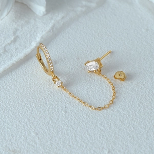 Macro-opname van de gouden S925 sterling zilveren kettingoorbellen met zirkonia steentjes