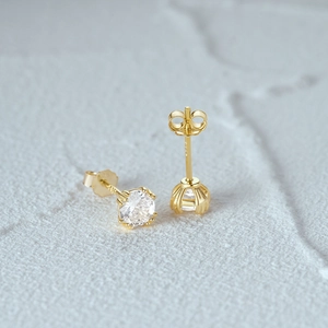 Gros plan de boucles d'oreilles en argent S925 doré avec zircons clairs sertis six griffes