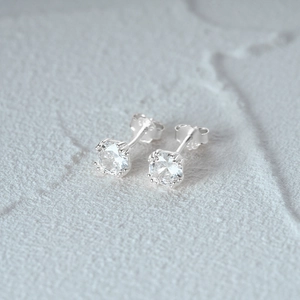 Détail d'une boucle d'oreille en argent S925 avec serti classique à six griffes brillantes