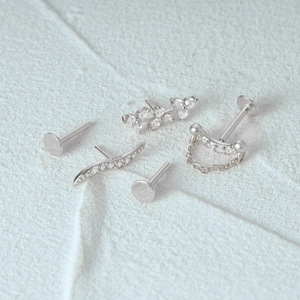 Macro-opname van S925 zilveren labret-studs met golf- en kettingontwerpen