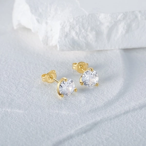 Gros plan d'une puce d'oreille en argent S925 doré avec zircon rond à trois griffes