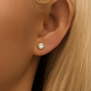 Gros plan de boucles d'oreilles halo en or avec cristaux ronds brillants sur l'oreille