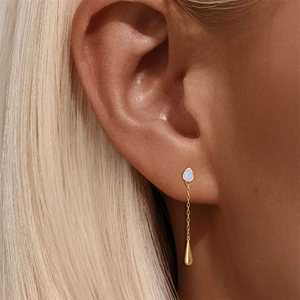 Close-up of long gold fringe earring with blue opal stone and droplet on model ear