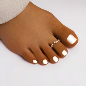 Detailed view of an S925 sterling silver hollow heart toe ring worn on the foot