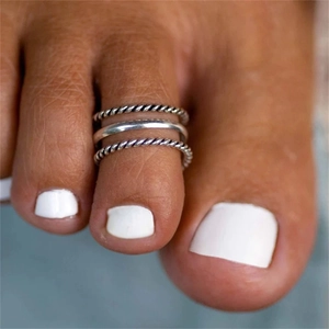 Close-up of three vintage S925 silver toe rings in twisted and minimalist styles