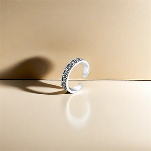 Close-up of S925 sterling silver lotus toe ring with vintage daisy floral relief details