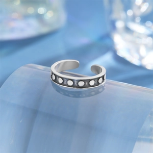 Macro detail of retro S925 sterling silver lotus toe ring with embossed dot texture