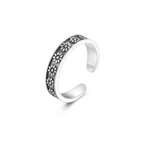 Macro detail of S925 sterling silver toe ring with vintage oxidized daisy patterns