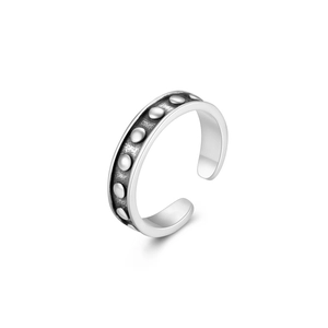 Macro detail of vintage S925 sterling silver toe ring with oxidized dots and open design