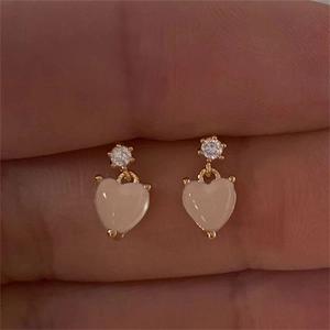 Dettaglio di orecchini a cuore rosa con zirconi cubici e placcatura in oro lucido