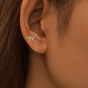 Vue macro d'une boucle d'oreille nœud en argent avec zircon sur le cartilage