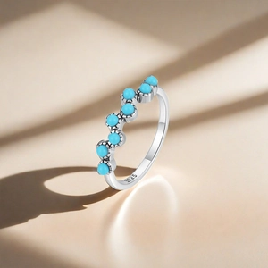 Macro shot of S925 silver ring with turquoise stones on wavy band and hallmark