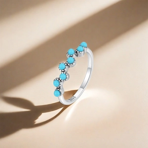 Macro detail of S925 sterling silver ring with seven turquoise stones in wave setting