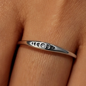 Macro shot of 925 sterling silver ring showing moon phase engraving on finger