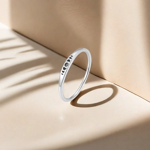 Detailed view of S925 sterling silver ring with moon phase engraving on beige surface