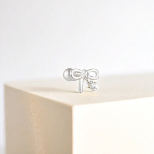 Détail macro du clou d'oreille noeud en argent S925 avec pendentif en zircone cubique