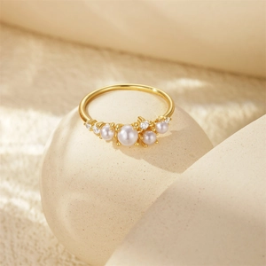 Makro-Detail des goldenen Cluster-Rings mit weißen Perlen und funkelnden Zirkonia