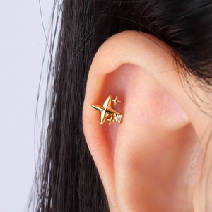 Détail du piercing d'oreille étoile dorée en argent avec petite pierre de zircone