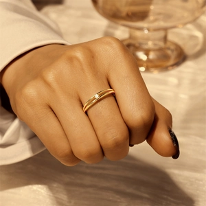 Detail eines eleganten, doppellagigen Goldrings mit funkelndem, rundem Edelstein