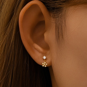 Détail de boucles d'oreilles fleurs en argent s925 doré avec zircons sur l'oreille